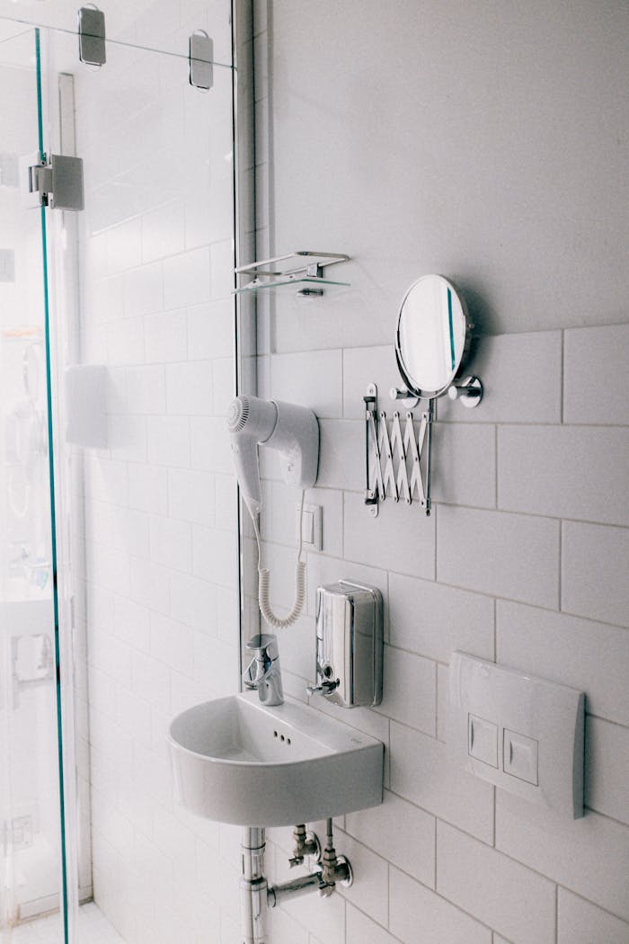 hero-img Sleek contemporary bathroom featuring a white sink and wall-mounted fixtures.
